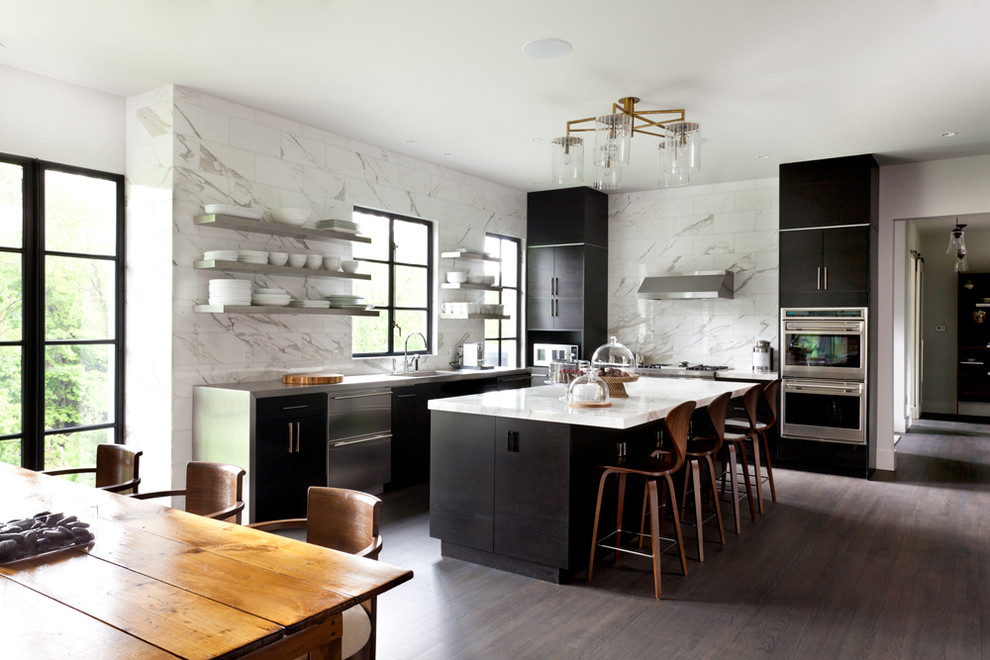 Foto på ett funkis kök och matrum, med en enkel diskho, vitt stänkskydd, stänkskydd i sten, rostfria vitvaror, mörkt trägolv, en köksö och släta luckor