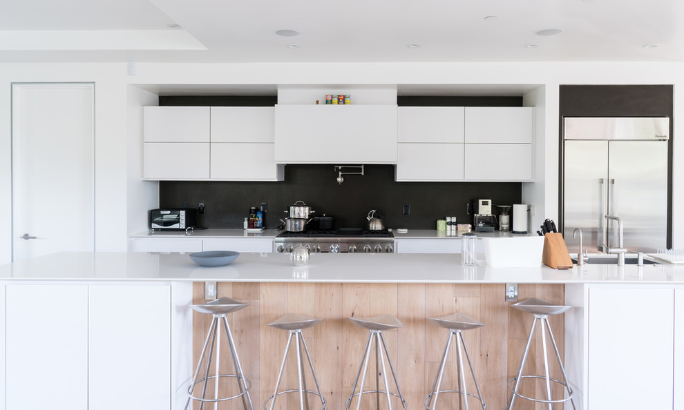Zweizeilige Moderne Küche mit Unterbauwaschbecken, flächenbündigen Schrankfronten, weißen Schränken, Küchengeräten aus Edelstahl und Kücheninsel in Washington, D.C.