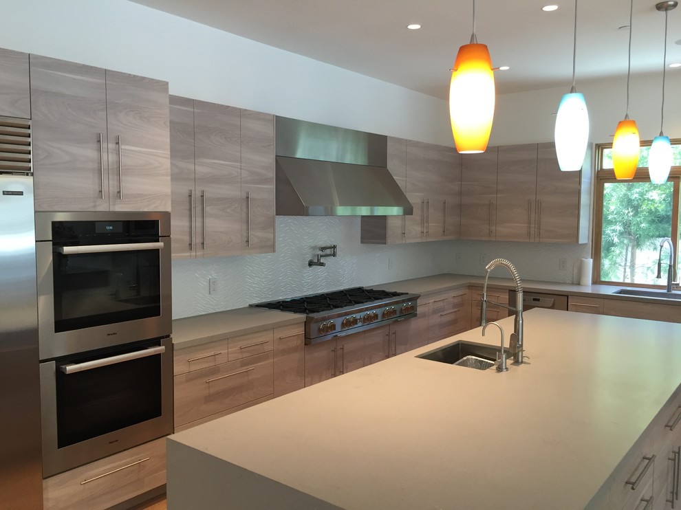 Inspiration for a large contemporary l-shaped enclosed kitchen remodel in Los Angeles with an undermount sink, flat-panel cabinets, light wood cabinets, quartz countertops, white backsplash, ceramic backsplash, stainless steel appliances and an island