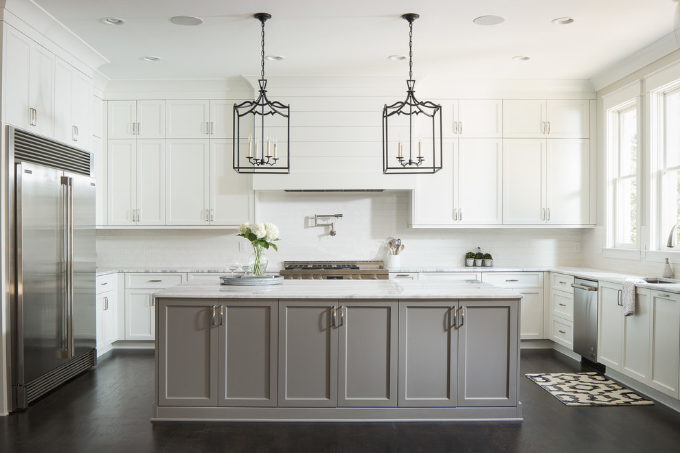 This is an example of a large traditional grey and white l-shaped kitchen in Atlanta with a submerged sink, shaker cabinets, white cabinets, marble worktops, white splashback, ceramic splashback, stainless steel appliances, an island, dark hardwood flooring and black floors.