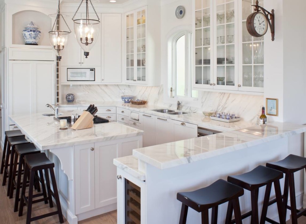 Idéer för att renovera ett litet funkis vit vitt kök, med en undermonterad diskho, marmorbänkskiva, vitt stänkskydd, stänkskydd i marmor, rostfria vitvaror, ljust trägolv, en köksö och brunt golv
