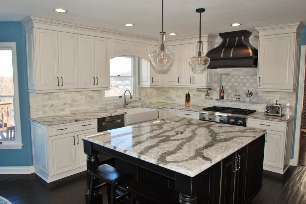 Example of a mid-sized trendy u-shaped dark wood floor kitchen design in Other with a farmhouse sink, raised-panel cabinets, white cabinets, quartzite countertops, white backsplash, cement tile backsplash, stainless steel appliances and an island