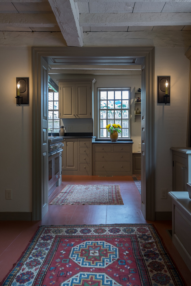 Example of a mid-sized cottage galley painted wood floor enclosed kitchen design in Boston with a farmhouse sink, raised-panel cabinets, gray cabinets, granite countertops, beige backsplash, stainless steel appliances and no island
