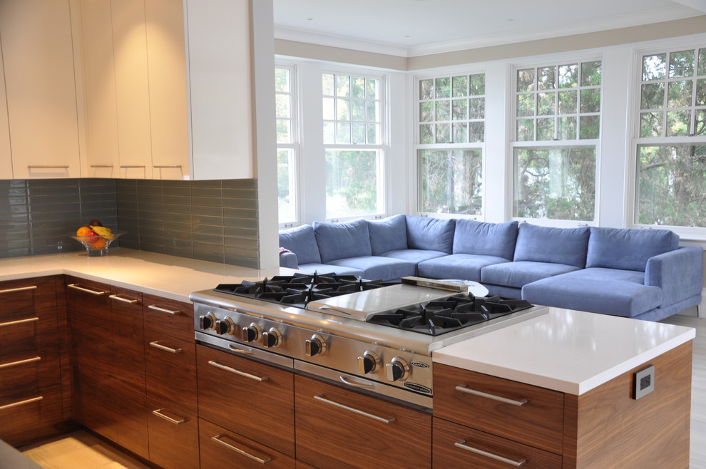 Foto på ett stort funkis kök, med en undermonterad diskho, släta luckor, bänkskiva i kvarts, blått stänkskydd, stänkskydd i glaskakel, rostfria vitvaror, vita skåp, ljust trägolv, en köksö och brunt golv