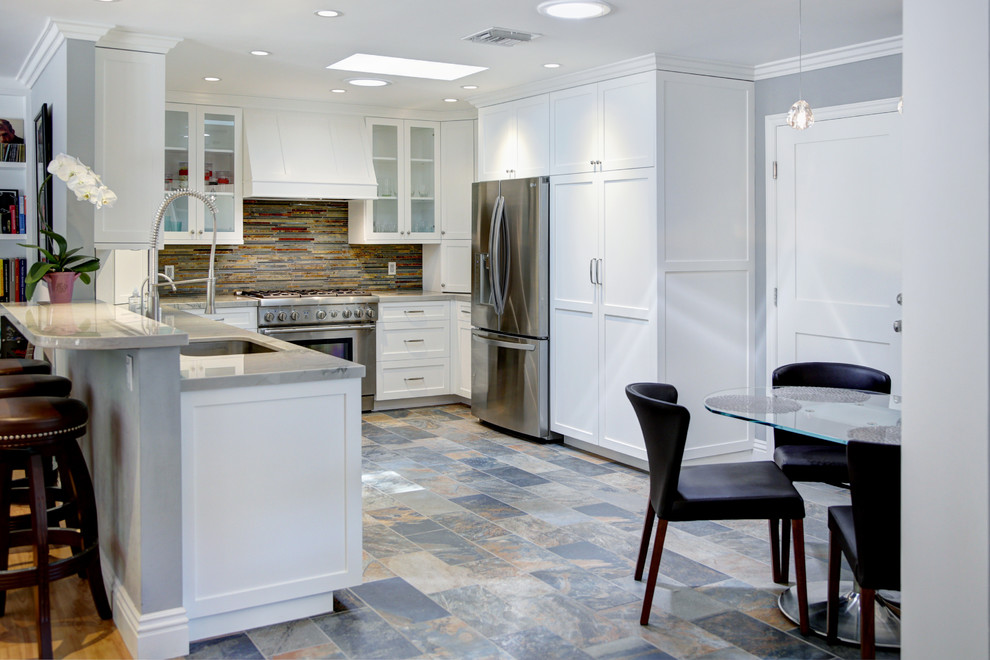 Eat-in kitchen - mid-sized transitional galley porcelain tile eat-in kitchen idea in Los Angeles with an undermount sink, shaker cabinets, white cabinets, quartzite countertops, multicolored backsplash, stone tile backsplash, stainless steel appliances and a peninsula