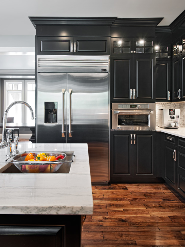 Inspiration for a timeless brown floor kitchen remodel in Ottawa with stainless steel appliances, a single-bowl sink, raised-panel cabinets, marble countertops, metallic backsplash and mosaic tile backsplash