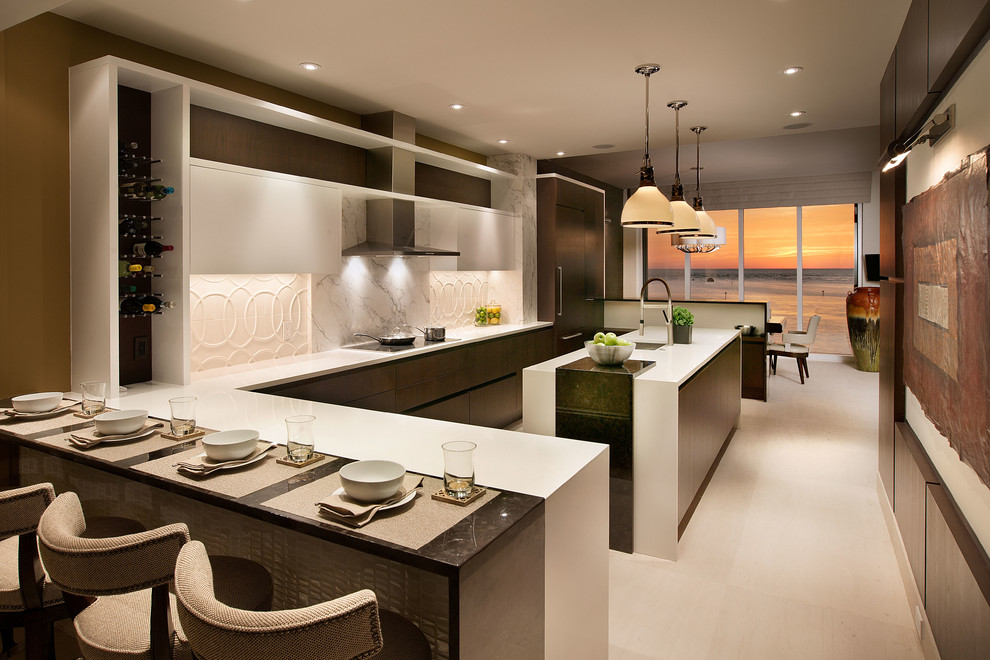 This is an example of a large contemporary u-shaped kitchen/diner in Miami with a submerged sink, flat-panel cabinets, dark wood cabinets, white splashback, integrated appliances, multiple islands, quartz worktops, ceramic splashback and limestone flooring.