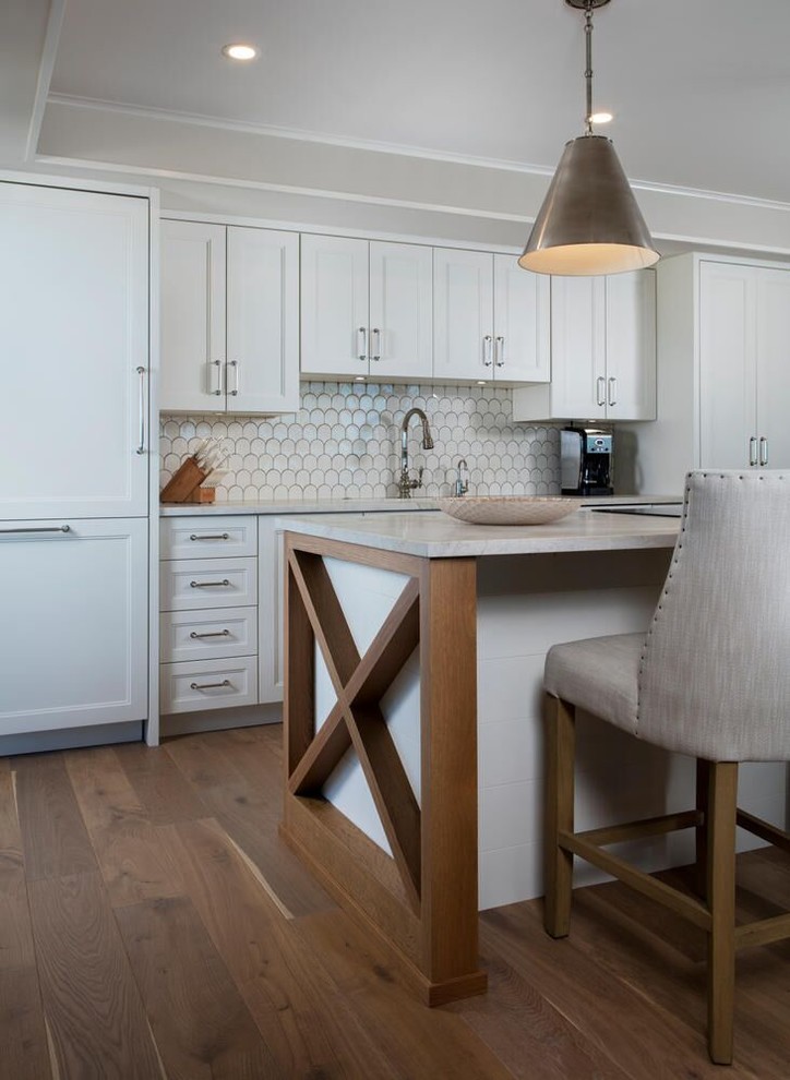 Foto på ett mellanstort funkis vit linjärt kök med öppen planlösning, med en undermonterad diskho, luckor med infälld panel, vita skåp, vitt stänkskydd, stänkskydd i keramik, integrerade vitvaror, mellanmörkt trägolv, en köksö och brunt golv