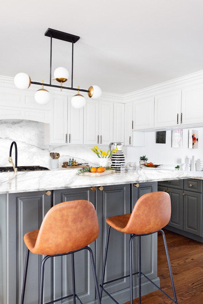 Mittelgroße Klassische Küche in L-Form mit profilierten Schrankfronten, grauen Schränken, Küchenrückwand in Weiß, Rückwand aus Stein, dunklem Holzboden, Kücheninsel, braunem Boden und weißer Arbeitsplatte in New York