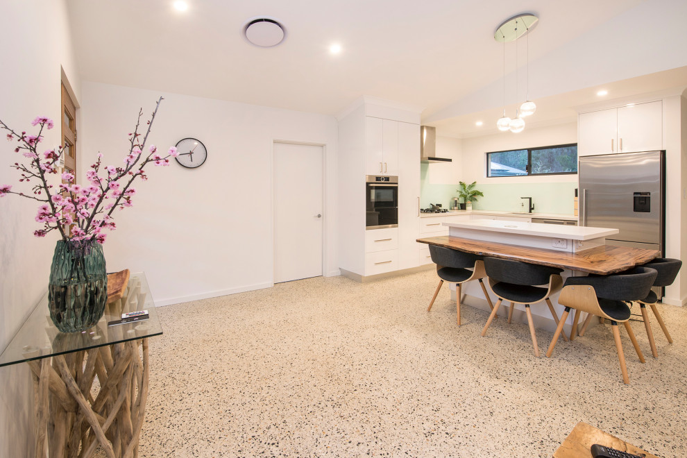 Идея дизайна: угловая кухня среднего размера в современном стиле с обеденным столом, бетонным полом и островом