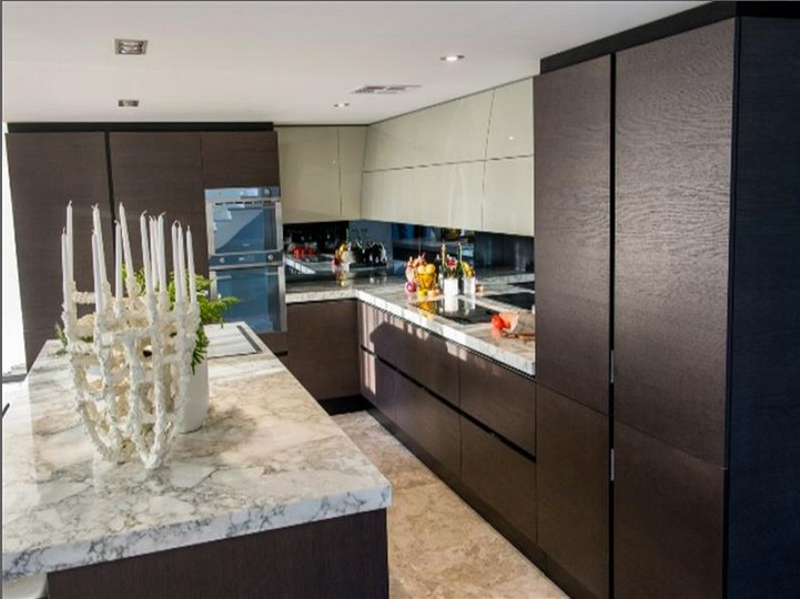 Inspiration for a large contemporary l-shaped open plan kitchen in Perth with a double-bowl sink, flat-panel cabinets, dark wood cabinets, marble worktops, black splashback, glass sheet splashback, stainless steel appliances, terrazzo flooring and an island.