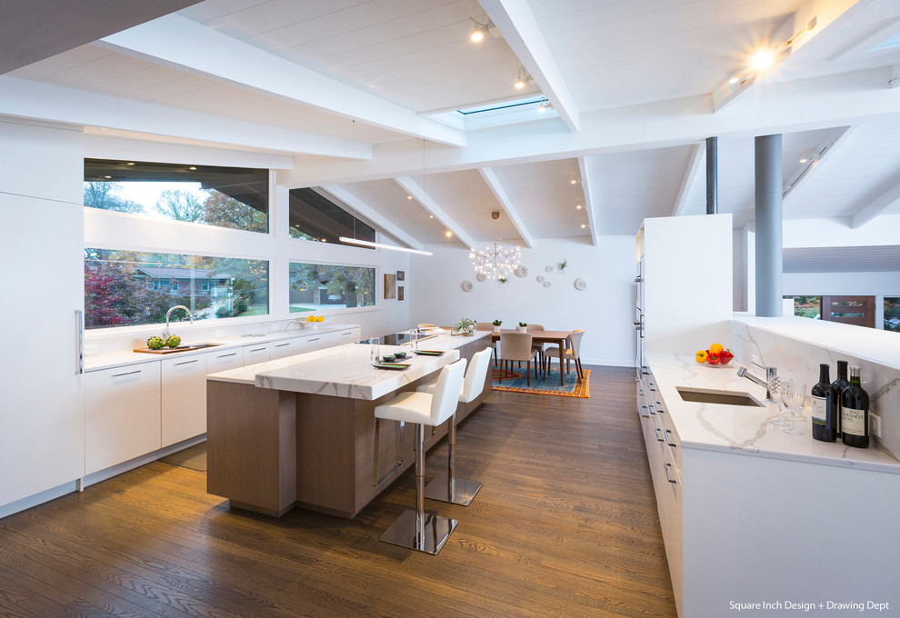 Bild på ett mellanstort kök, med en undermonterad diskho, släta luckor, vita skåp, bänkskiva i kvarts, vitt stänkskydd, stänkskydd i sten, integrerade vitvaror, mörkt trägolv och en köksö