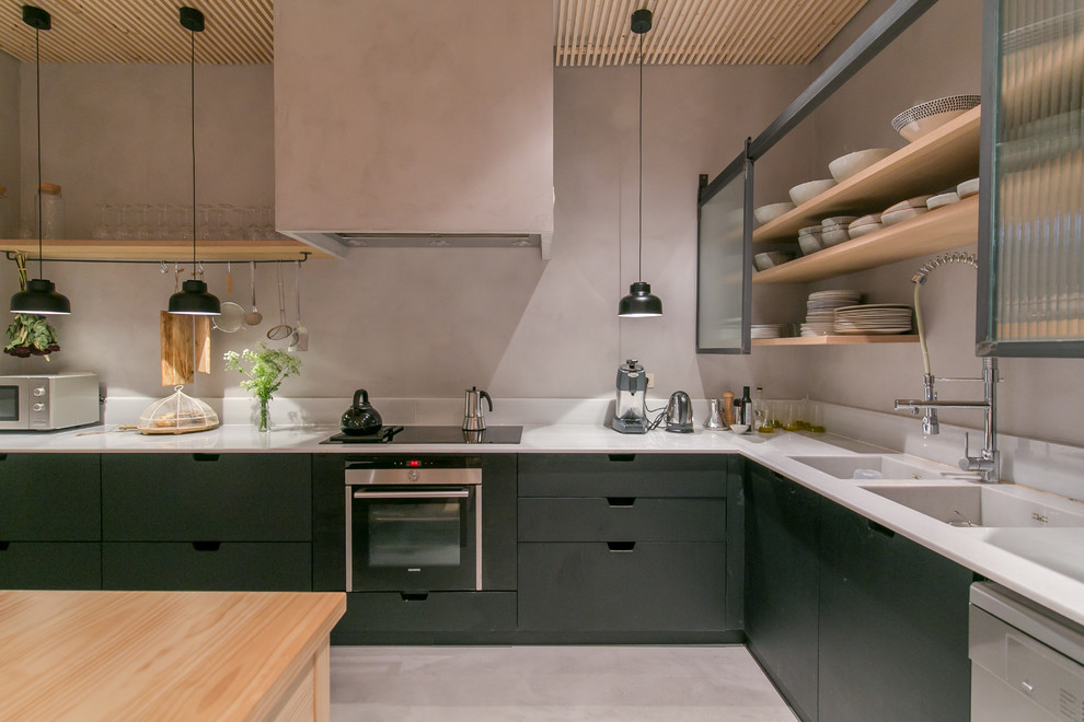 This is an example of a large scandinavian l-shaped enclosed kitchen in Barcelona with an integrated sink, open cabinets, composite countertops, grey splashback, cement tile splashback, stainless steel appliances, concrete flooring, an island and black cabinets.