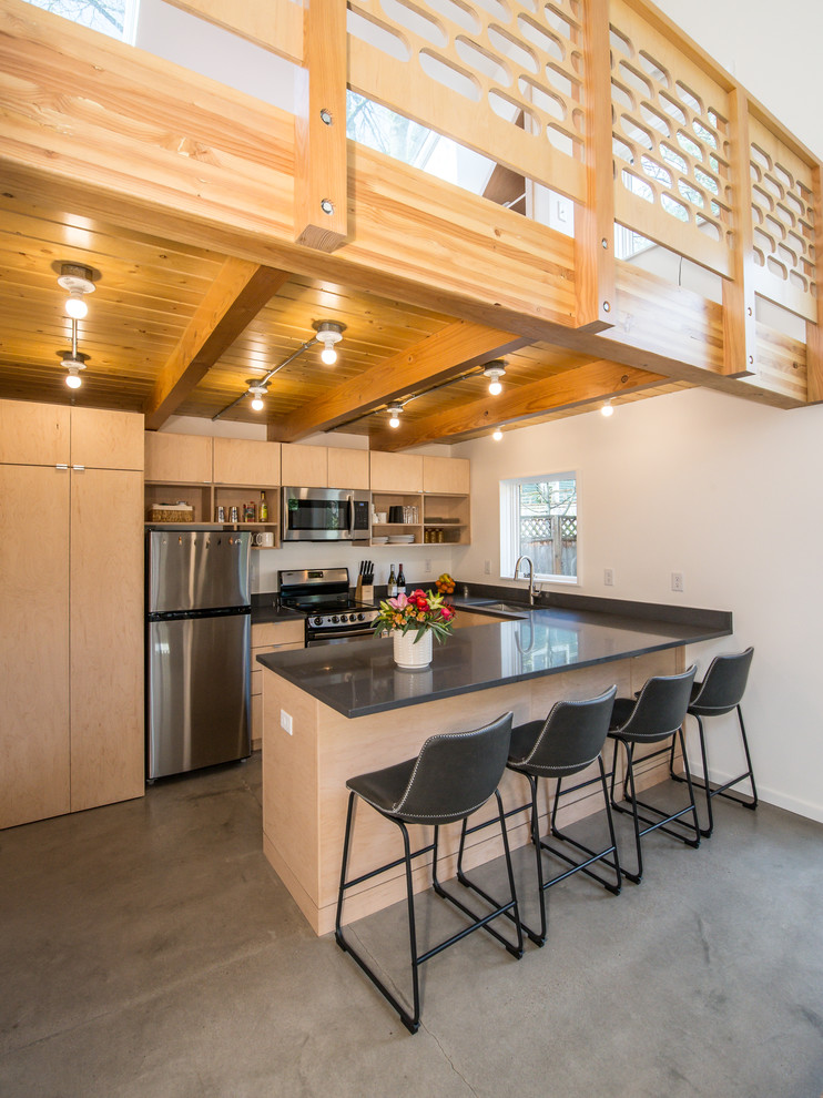 Exempel på ett mellanstort modernt grå grått kök, med en undermonterad diskho, släta luckor, skåp i ljust trä, vitt stänkskydd, rostfria vitvaror, betonggolv, en halv köksö, grått golv och bänkskiva i koppar
