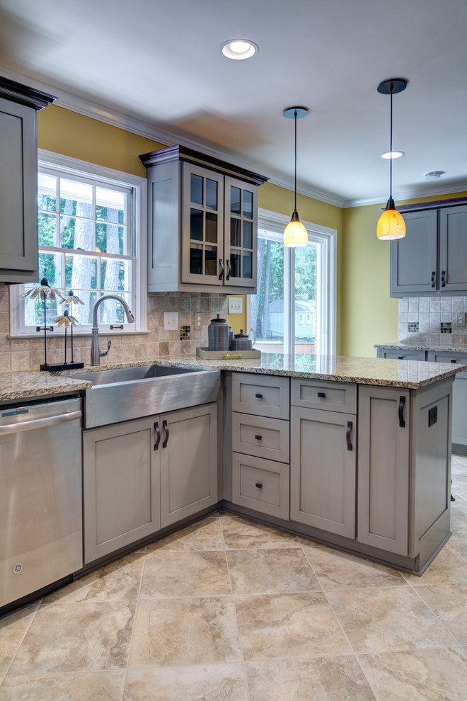 Mid-sized transitional l-shaped porcelain tile eat-in kitchen photo in Atlanta with a farmhouse sink, shaker cabinets, gray cabinets, granite countertops, beige backsplash, stone tile backsplash, stainless steel appliances and a peninsula