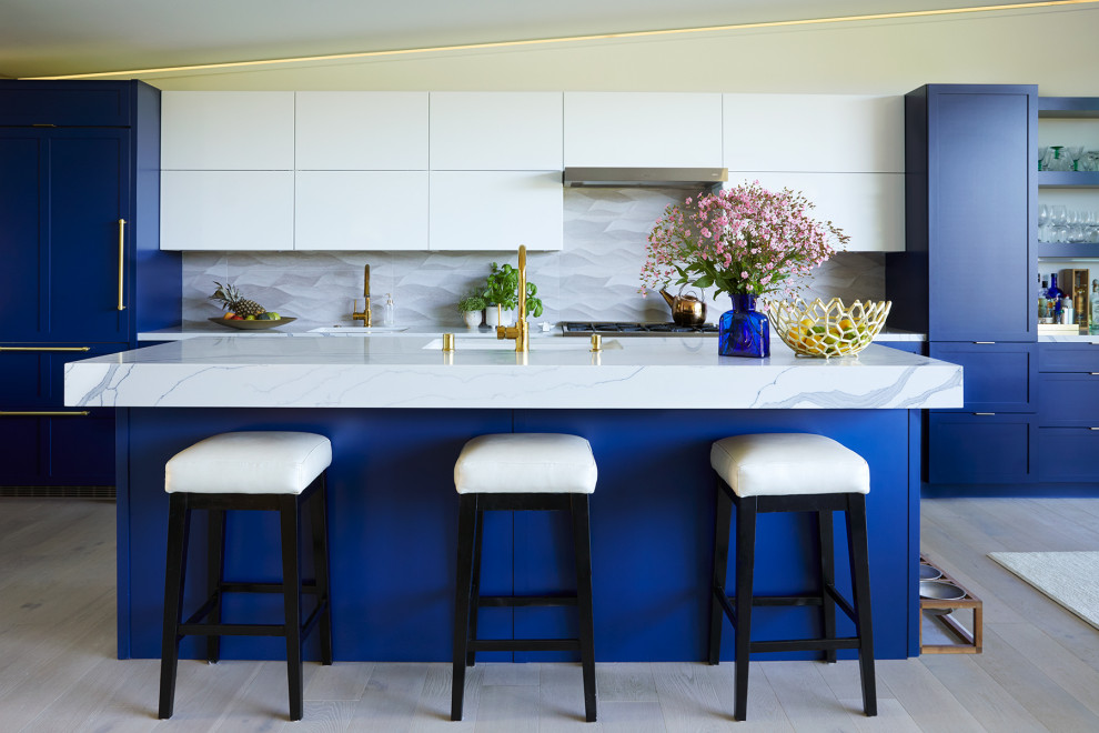 Inspiration for a contemporary galley light wood floor and beige floor kitchen remodel in San Francisco with an undermount sink, shaker cabinets, blue cabinets, gray backsplash, stainless steel appliances, an island and white countertops