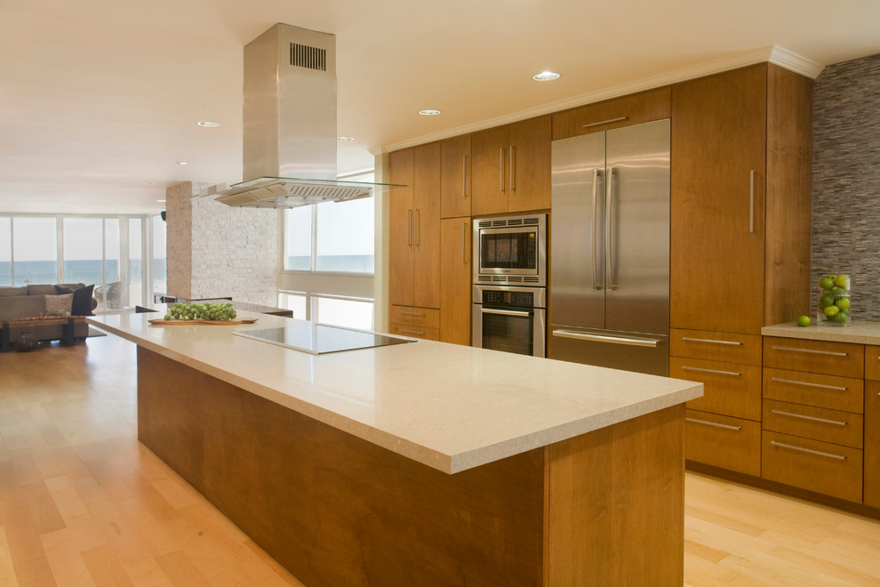 Example of a large trendy galley light wood floor open concept kitchen design in Dallas with an undermount sink, flat-panel cabinets, medium tone wood cabinets, quartz countertops, blue backsplash, mosaic tile backsplash, stainless steel appliances and an island