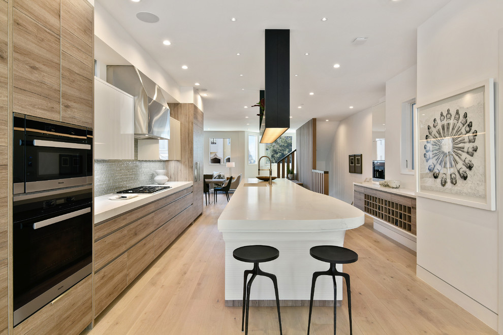Exempel på ett modernt kök, med en undermonterad diskho, släta luckor, skåp i mellenmörkt trä, bänkskiva i kvarts, stänkskydd med metallisk yta, stänkskydd i glaskakel, integrerade vitvaror, ljust trägolv, en köksö och beiget golv