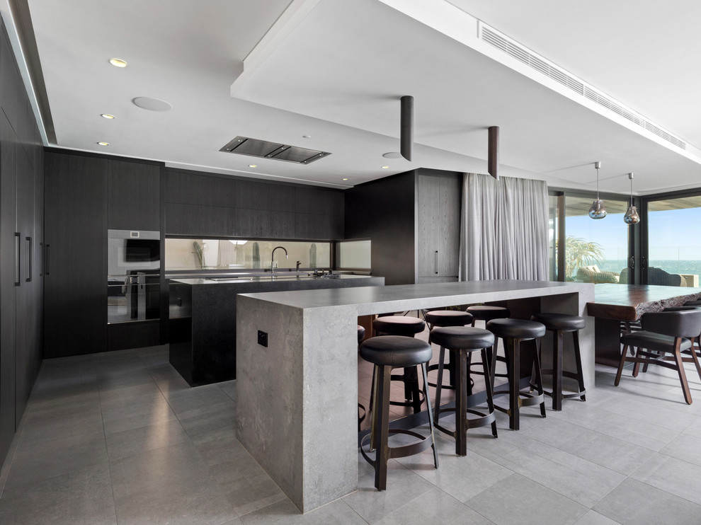 Moderne Küche in L-Form mit flächenbündigen Schrankfronten, schwarzen Schränken, Rückwand-Fenster, schwarzen Elektrogeräten, zwei Kücheninseln, grauem Boden und grauer Arbeitsplatte in Perth