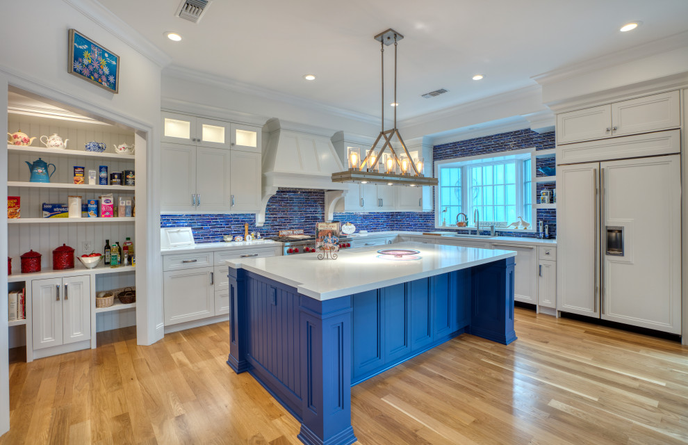 Eat-in kitchen - large traditional l-shaped eat-in kitchen idea in Los Angeles with recessed-panel cabinets, white cabinets, marble countertops, blue backsplash, matchstick tile backsplash, stainless steel appliances, an island, white countertops and an undermount sink