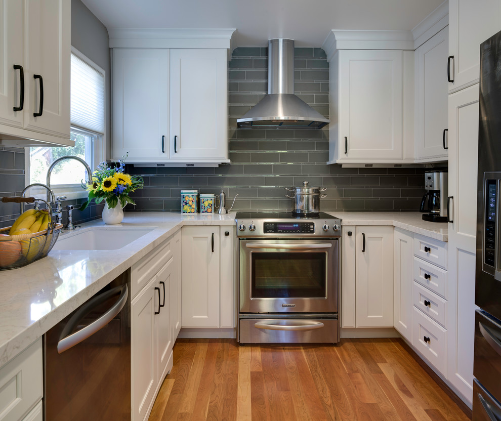 Inspiration for a timeless u-shaped enclosed kitchen remodel in San Francisco with an undermount sink, recessed-panel cabinets, white cabinets, gray backsplash, stainless steel appliances and quartz countertops