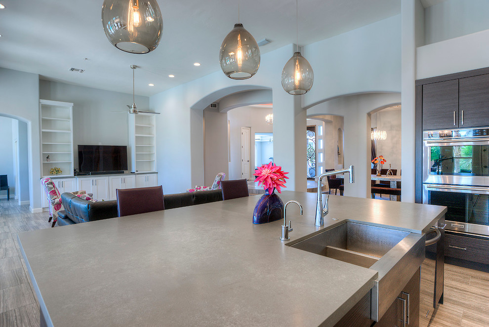 Example of a mid-sized minimalist l-shaped eat-in kitchen design in Phoenix with flat-panel cabinets, dark wood cabinets, gray backsplash, stainless steel appliances and an island