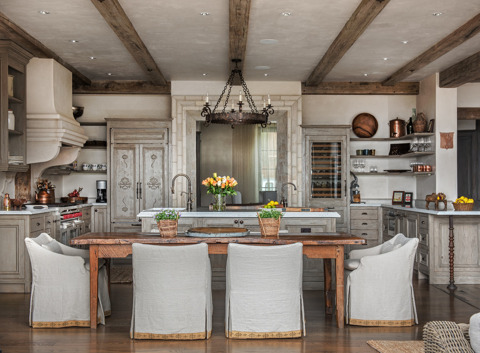 Foto på ett medelhavsstil u-kök, med luckor med upphöjd panel, skåp i ljust trä, integrerade vitvaror, mörkt trägolv och en köksö