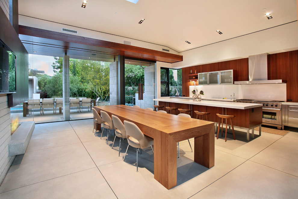 Moderne Wohnküche mit flächenbündigen Schrankfronten, dunklen Holzschränken und Küchengeräten aus Edelstahl in Orange County