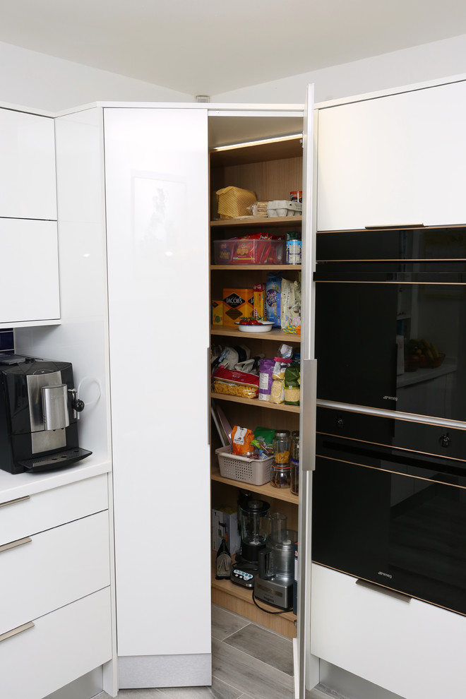 Photo of a medium sized contemporary u-shaped enclosed kitchen in Other with an integrated sink, flat-panel cabinets, white cabinets, composite countertops, blue splashback, ceramic splashback, black appliances and white worktops.