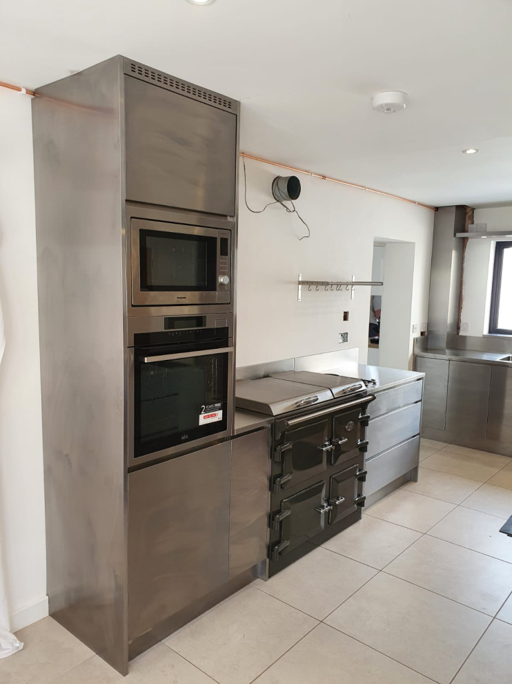 Moderne Küche mit integriertem Waschbecken, Edelstahlfronten, Edelstahl-Arbeitsplatte und Küchengeräten aus Edelstahl in Hertfordshire