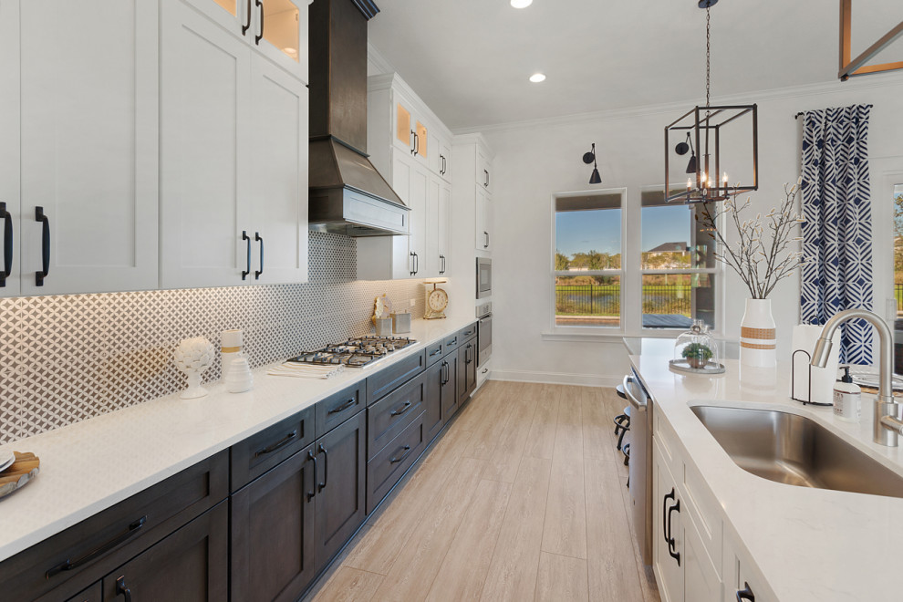 Inspiration for a large industrial single-wall vinyl floor and gray floor open concept kitchen remodel in Jacksonville with a single-bowl sink, shaker cabinets, white cabinets, quartz countertops, black backsplash, porcelain backsplash, stainless steel appliances, an island and white countertops