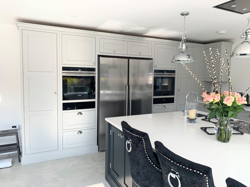 Immagine di una grande cucina chic con lavello sottopiano, ante grigie, top in quarzite, elettrodomestici neri, pavimento in gres porcellanato, pavimento grigio e top bianco