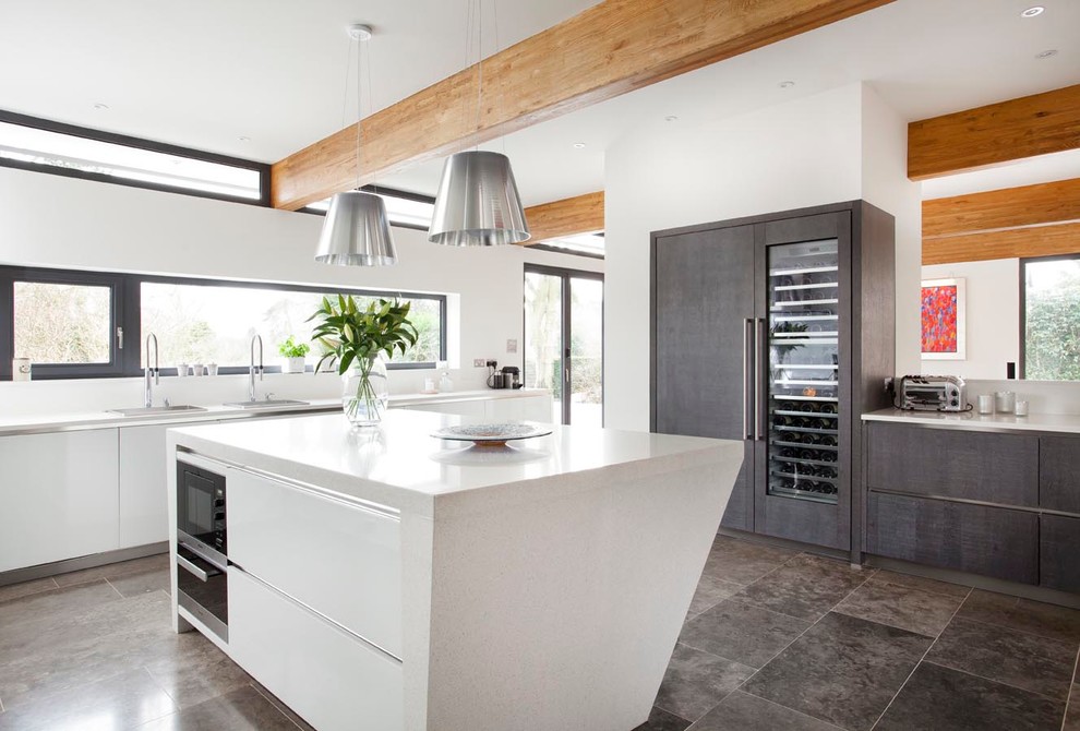 Photo of a large contemporary open plan kitchen in Other with a submerged sink, flat-panel cabinets, grey cabinets, quartz worktops, white splashback, glass sheet splashback, stainless steel appliances, ceramic flooring and an island.