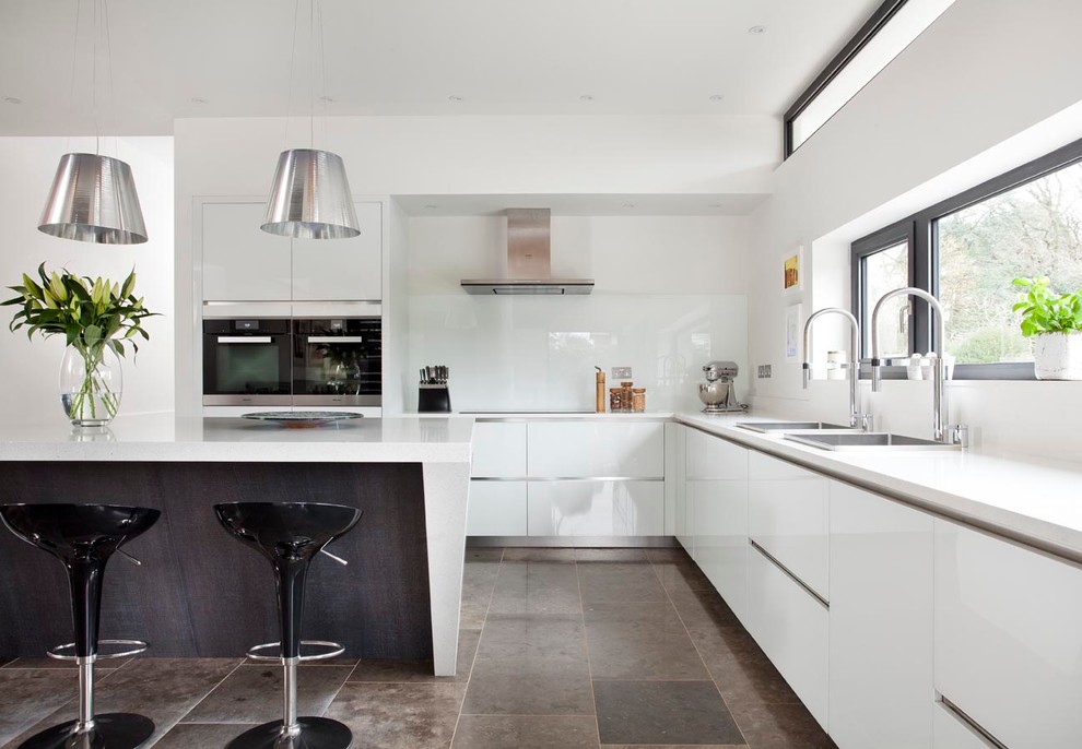 Inspiration for a large contemporary open plan kitchen in Other with a submerged sink, flat-panel cabinets, grey cabinets, quartz worktops, white splashback, glass sheet splashback, stainless steel appliances, ceramic flooring and an island.