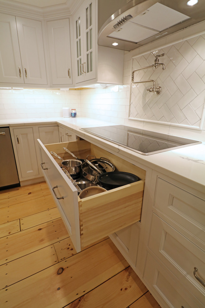 ボストンにある高級な広いトランジショナルスタイルのおしゃれなキッチン (エプロンフロントシンク、インセット扉のキャビネット、白いキャビネット、クオーツストーンカウンター、白いキッチンパネル、磁器タイルのキッチンパネル、シルバーの調理設備、淡色無垢フローリング、黄色い床、白いキッチンカウンター) の写真