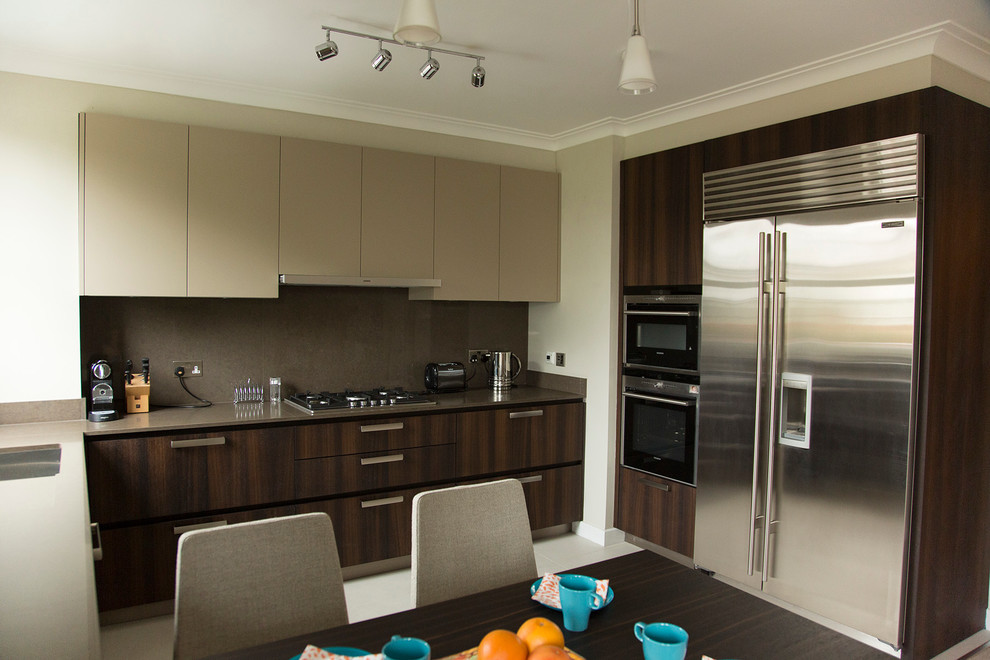 Eat-in kitchen - mid-sized contemporary u-shaped ceramic tile eat-in kitchen idea in London with an undermount sink, flat-panel cabinets, dark wood cabinets, quartz countertops, brown backsplash, stainless steel appliances and no island