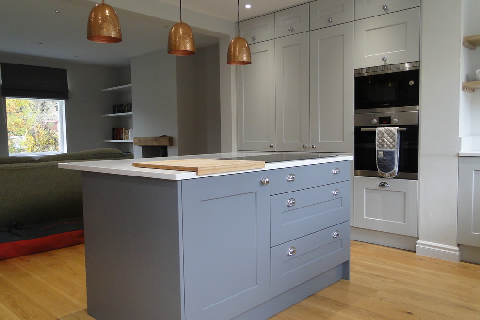 Foto di una cucina minimal di medie dimensioni con ante in stile shaker, ante grigie, top in quarzite, elettrodomestici in acciaio inossidabile e lavello integrato