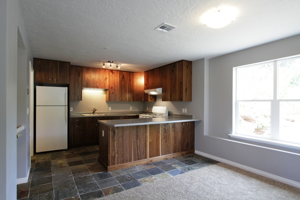 Aménagement d'une petite cuisine ouverte classique en U et bois brun avec un évier posé, un placard à porte plane, un plan de travail en stratifié, un électroménager blanc et un sol en ardoise.