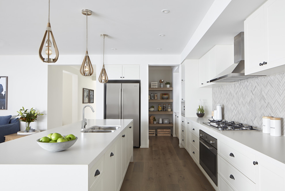 Inspiration for a contemporary galley kitchen in Melbourne with a built-in sink, recessed-panel cabinets, white cabinets, engineered stone countertops, grey splashback, stainless steel appliances, dark hardwood flooring, brown floors and white worktops.