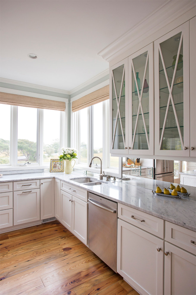 Imagen de cocina costera con fregadero de doble seno, armarios tipo vitrina y puertas de armario blancas