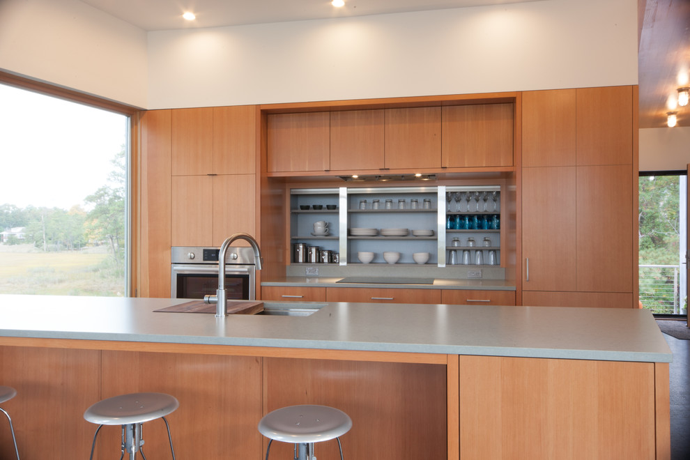 This is an example of a large modern single-wall kitchen/diner in Other with a single-bowl sink, flat-panel cabinets, medium wood cabinets, quartz worktops, integrated appliances, cork flooring and an island.