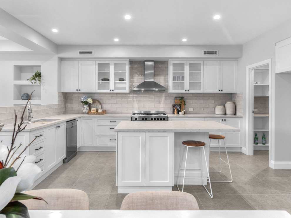 Exempel på ett stort klassiskt grå grått kök, med en undermonterad diskho, skåp i shakerstil, vita skåp, grått stänkskydd, rostfria vitvaror, en köksö och grått golv