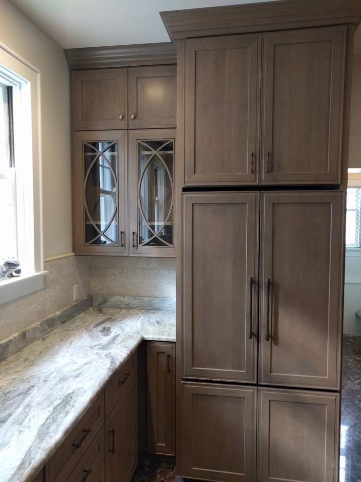 Enclosed kitchen - huge traditional galley marble floor enclosed kitchen idea in Huntington with an undermount sink, recessed-panel cabinets, brown cabinets, granite countertops, white backsplash, stone tile backsplash and stainless steel appliances