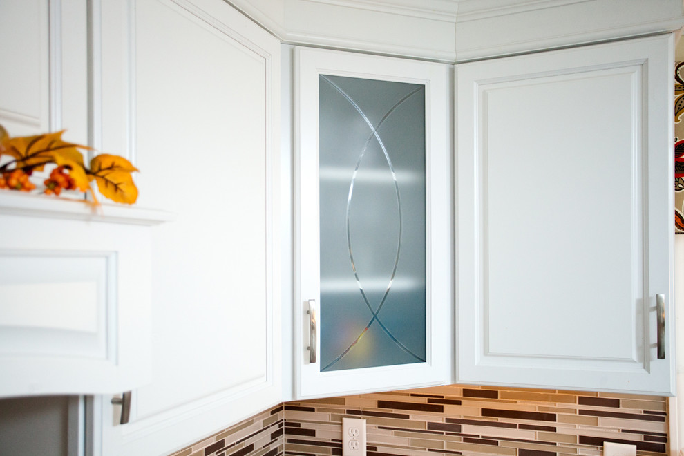 Exempel på ett stort modernt kök, med en enkel diskho, luckor med upphöjd panel, vita skåp, granitbänkskiva, flerfärgad stänkskydd, glaspanel som stänkskydd och rostfria vitvaror