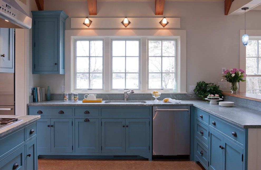 Maritim inredning av ett kök, med skåp i shakerstil, blå skåp, marmorbänkskiva och rostfria vitvaror