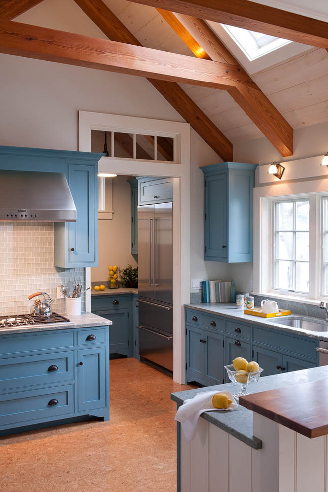 Diseño de cocina marinera con fregadero bajoencimera, armarios estilo shaker, puertas de armario azules, encimera de mármol, salpicadero blanco, salpicadero de azulejos de vidrio y barras de cocina