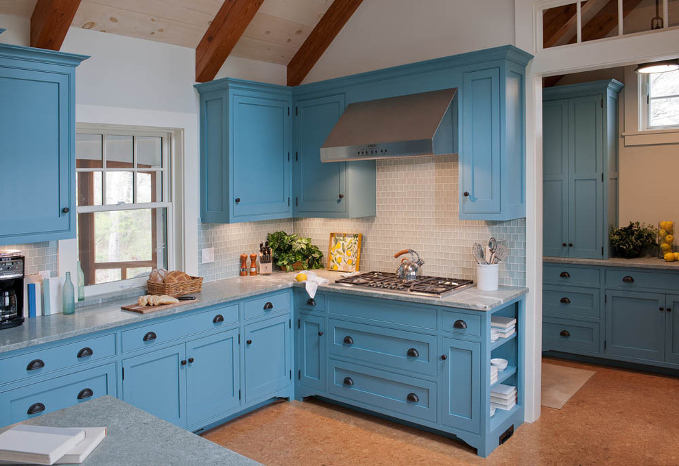 Foto de cocina costera con armarios estilo shaker, puertas de armario azules, encimera de mármol y salpicadero de azulejos de vidrio