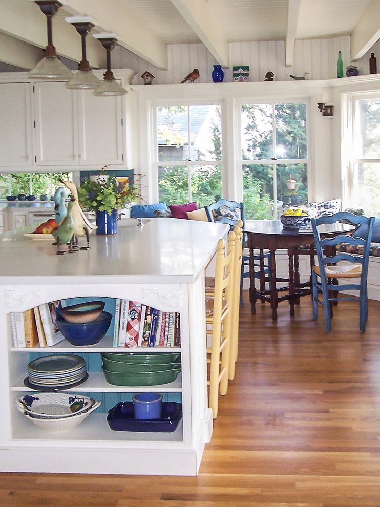 Immagine di una cucina costiera di medie dimensioni con ante a filo, ante bianche, lavello a vasca singola, top in superficie solida, paraspruzzi blu, elettrodomestici bianchi, parquet chiaro e top bianco
