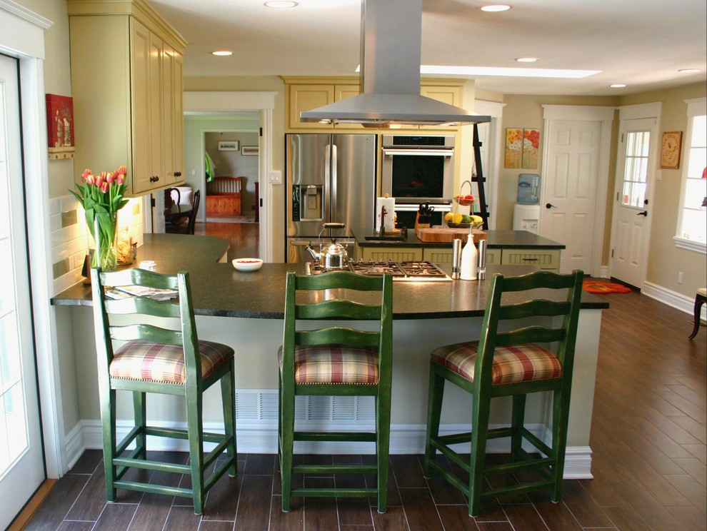 Exempel på ett klassiskt kök, med en rustik diskho, skåp i shakerstil, gula skåp, granitbänkskiva, gult stänkskydd, stänkskydd i keramik, rostfria vitvaror och en köksö