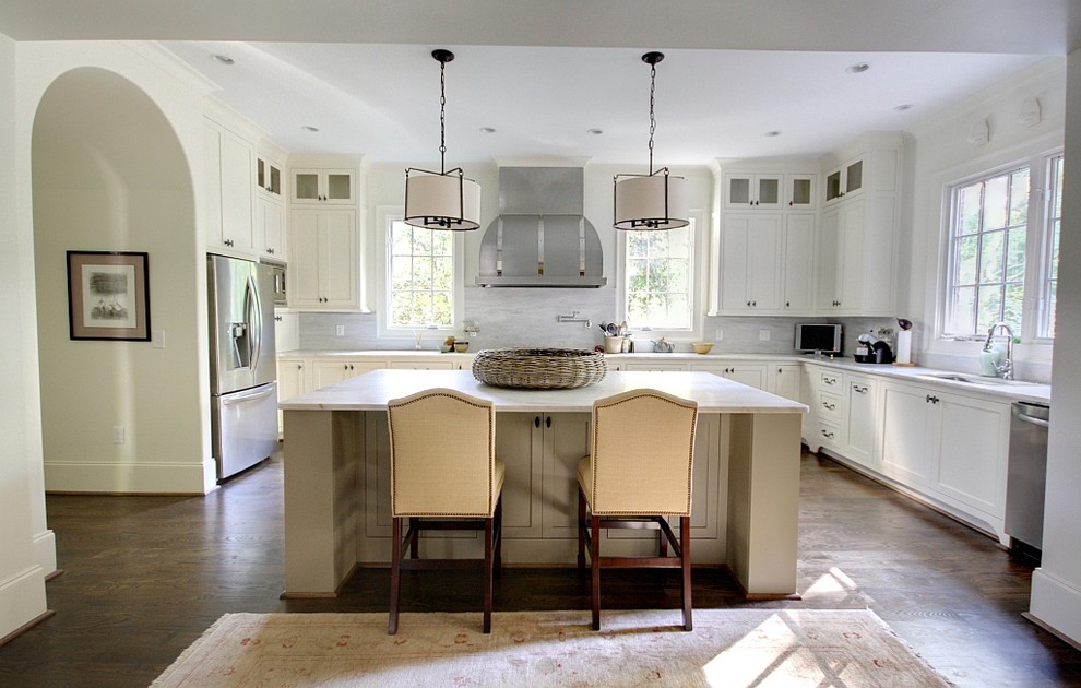 На фото: п-образная кухня в классическом стиле с фасадами в стиле шейкер, белыми фасадами, техникой из нержавеющей стали и телевизором с